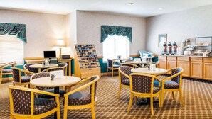 A hotel lobby with round tables and chairs, a coffee station, and a display of magazines. - Comfort Inn Goshen (Goshen)