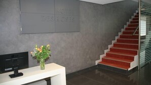 A hotel reception area with a modern staircase and a reception desk. - Hotel Des Roses (Kifisia)
