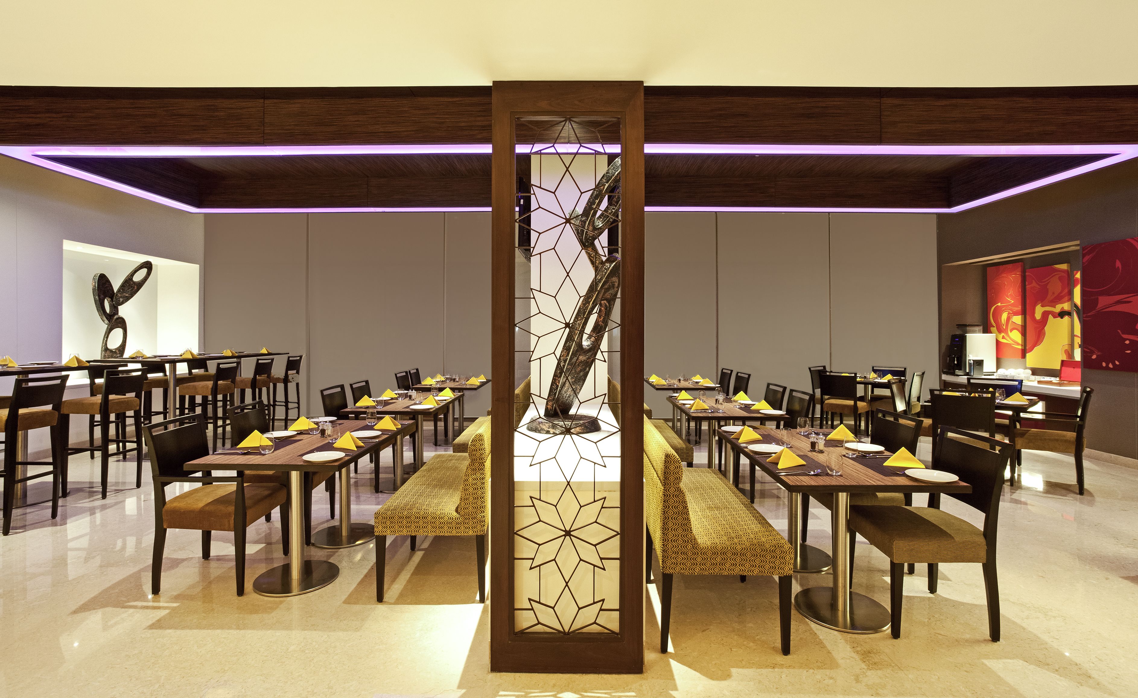A spacious conference room with long tables, chairs, and a central decorative column.