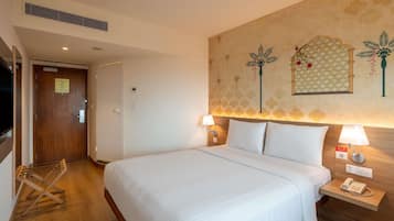 Una camera d'albergo con un letto grande, due comodini con lampade, un telefono a muro e una porta con un cartello.