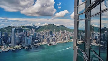 A high-rise building with a view of a cityscape and a body of water.