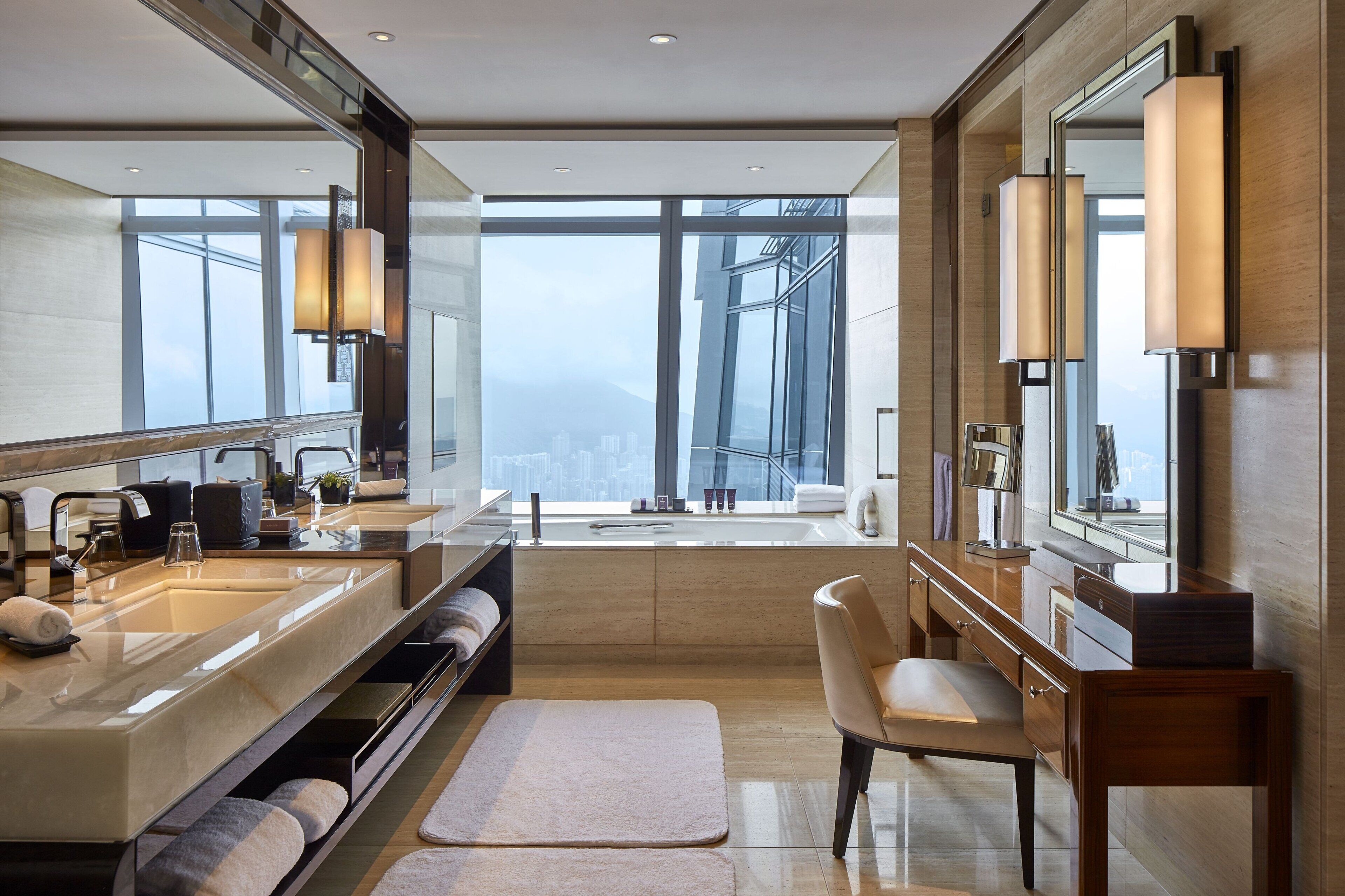 A modern bathroom with dual sinks, a large mirror, and a view of a cityscape.