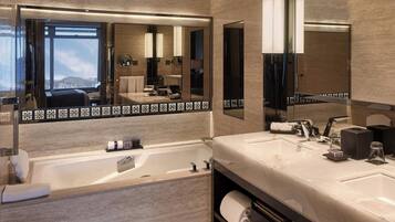 Une salle de bain moderne avec un grand miroir, une baignoire et un meuble-lavabo.