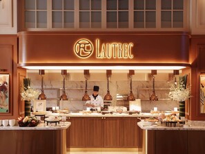A restaurant with a sign reading 'LAUTREC,' a chef preparing food, and a buffet with various dishes.