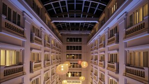 A multi-story hotel interior with a central atrium, balconies, and hanging spherical light fixtures.