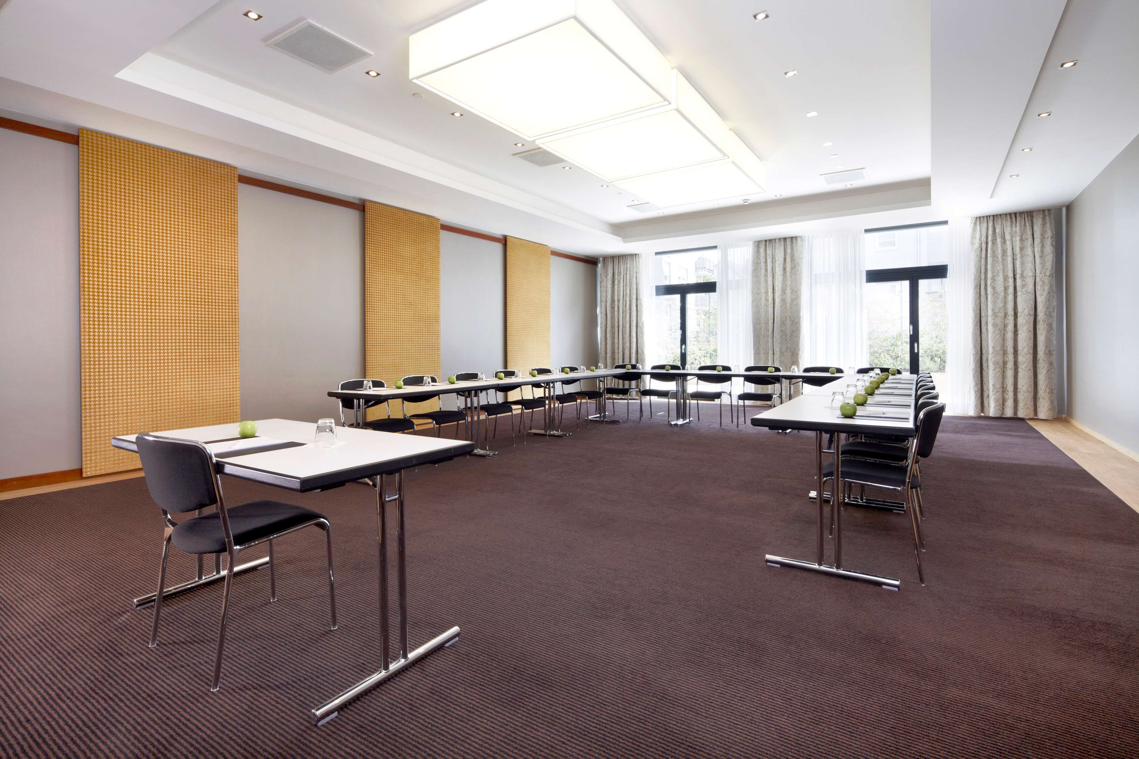 Ein Konferenzraum mit einem langen Tisch, Stühlen und Teppichboden.