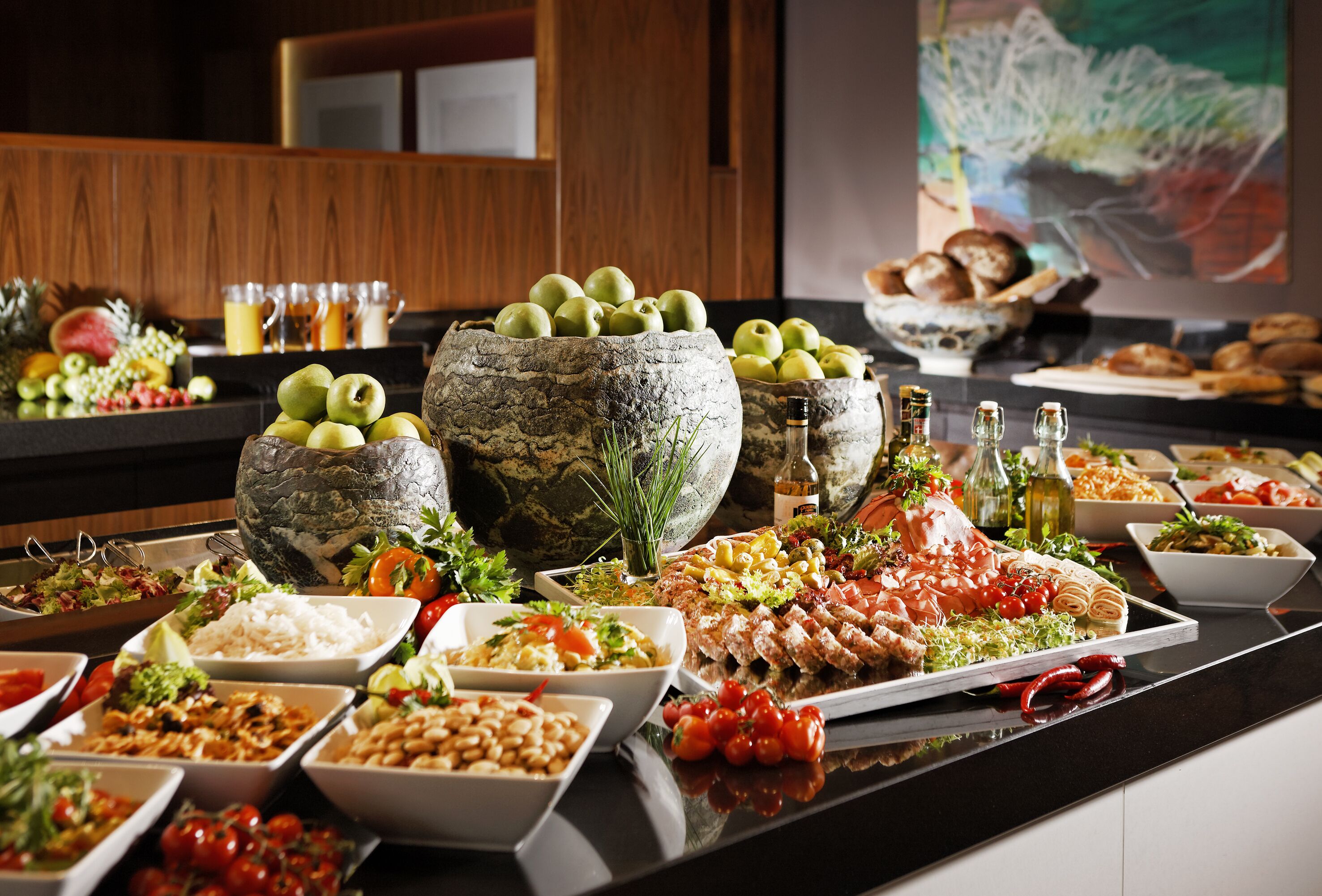 A buffet table with various food items and a stone centerpiece.