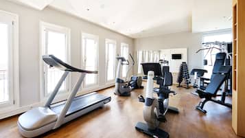 Un gimnasio amplio en casa con cinta de correr, elíptica y máquinas de pesas.