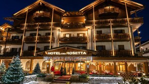 A multi-story hotel with balconies, a restaurant, and a Christmas tree display.