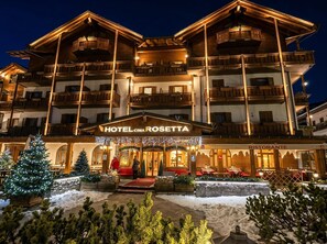 A multi-story hotel with balconies, a restaurant, and a Christmas tree display.