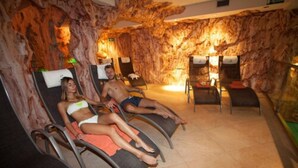 A spa area with reclining chairs, a rock wall, and a small table with chairs.