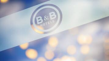 Un logotipo con el texto "B&B HOTELS" sobre una superficie reflectante.