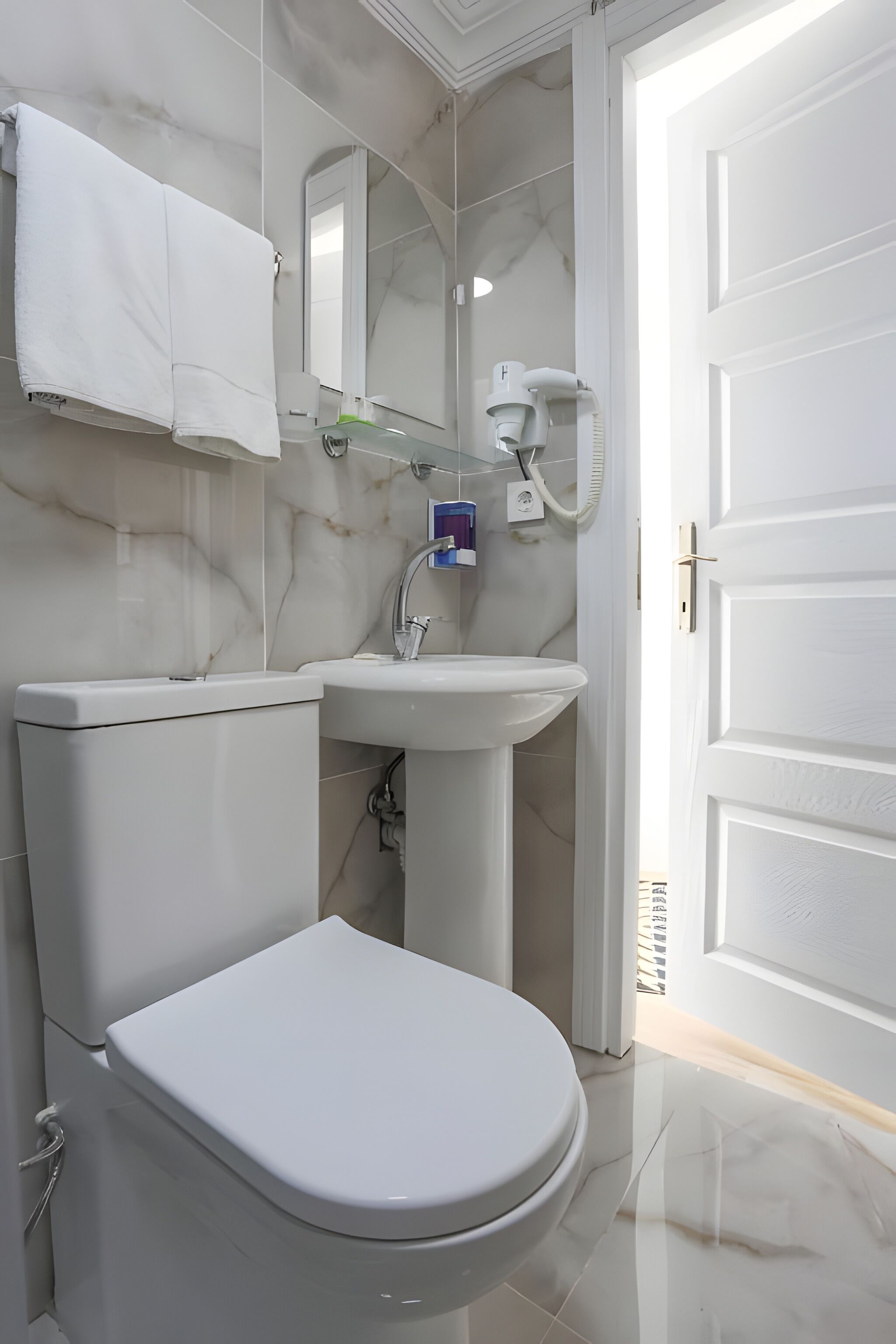 Une salle de bain moderne avec des toilettes, un lavabo et un miroir.