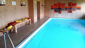 Piscina con paredes y bancos de madera.