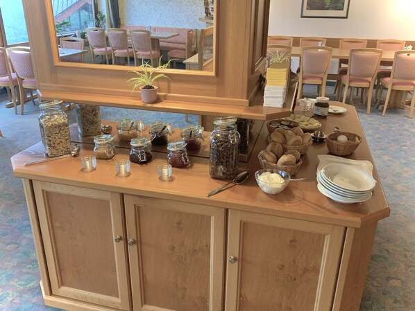 A buffet counter with various food items and condiments. - Hotel Schauinsland (Bad Peterstal-Griesbach)