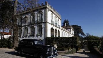 Un bâtiment historique devant lequel est garée une voiture d’époque.