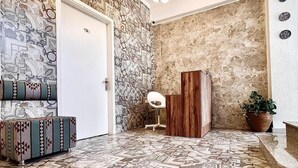 Eine großzügige Lobby mit gemustertem Boden, einer weißen Tür, einem Holzschrank und einem Blumentopf.