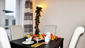 Una mesa de comedor dispuesta con una taza, platillo, tetera y un plato con comida.