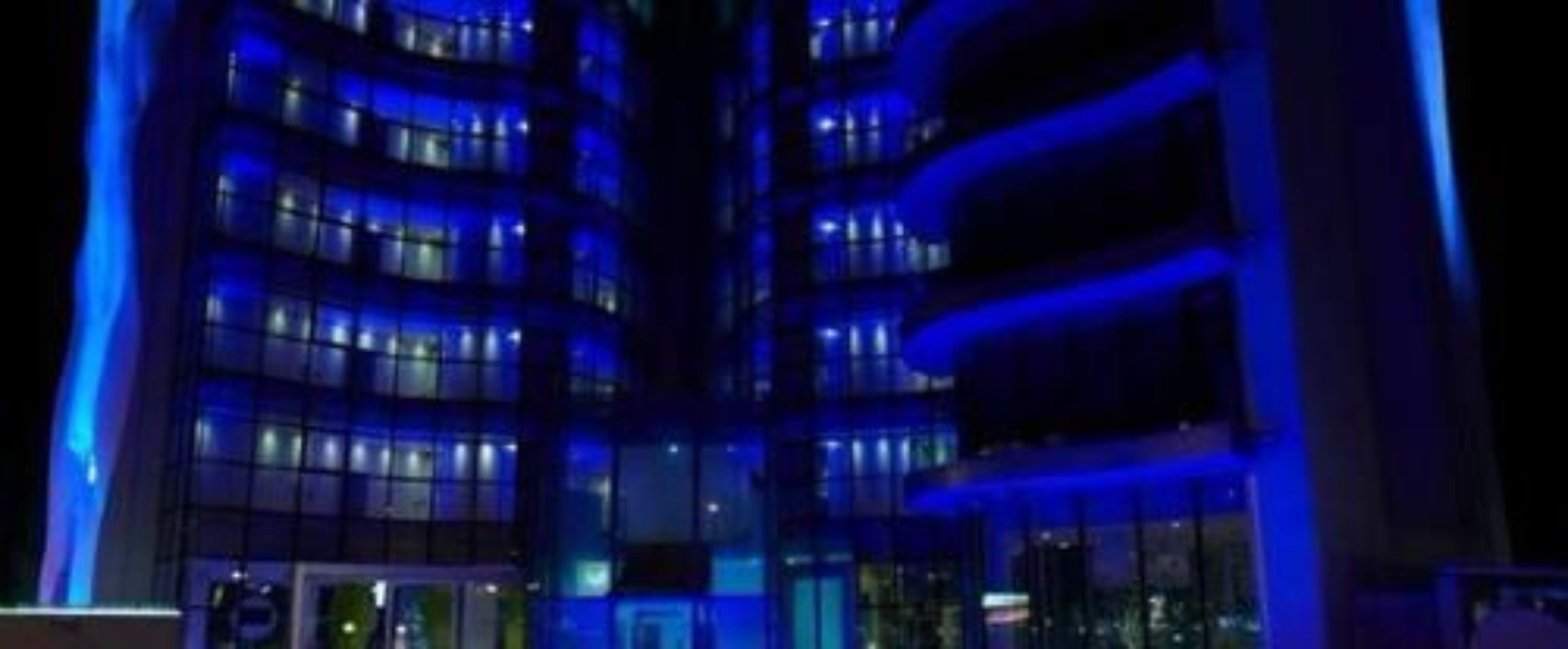 A multi-story building with illuminated windows at night.