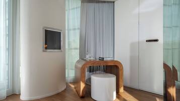 Une pièce moderne avec une table en bois, un tabouret blanc, une vitrine et une porte coulissante.