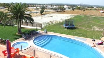 Relax by the pool surrounded by a lush lawn and comfortable seating options.