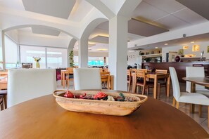 A dining area with a wooden table, wicker baskets, and chairs. - Casa Do Vale Hotel (Évora)