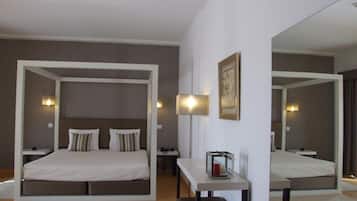 A modern bedroom with a large bed, bedside tables, a desk, and a mirror.