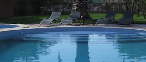 Alberca al aire libre y camastros