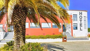 A hotel with a red facade, white exterior walls, and a sign reading "HOTEL". - Casa Do Vale Hotel (Évora)