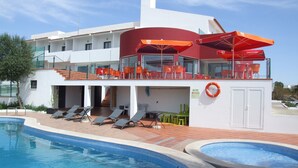A modern hotel with a pool, outdoor seating, and a lifebuoy. - Casa Do Vale Hotel (Évora)