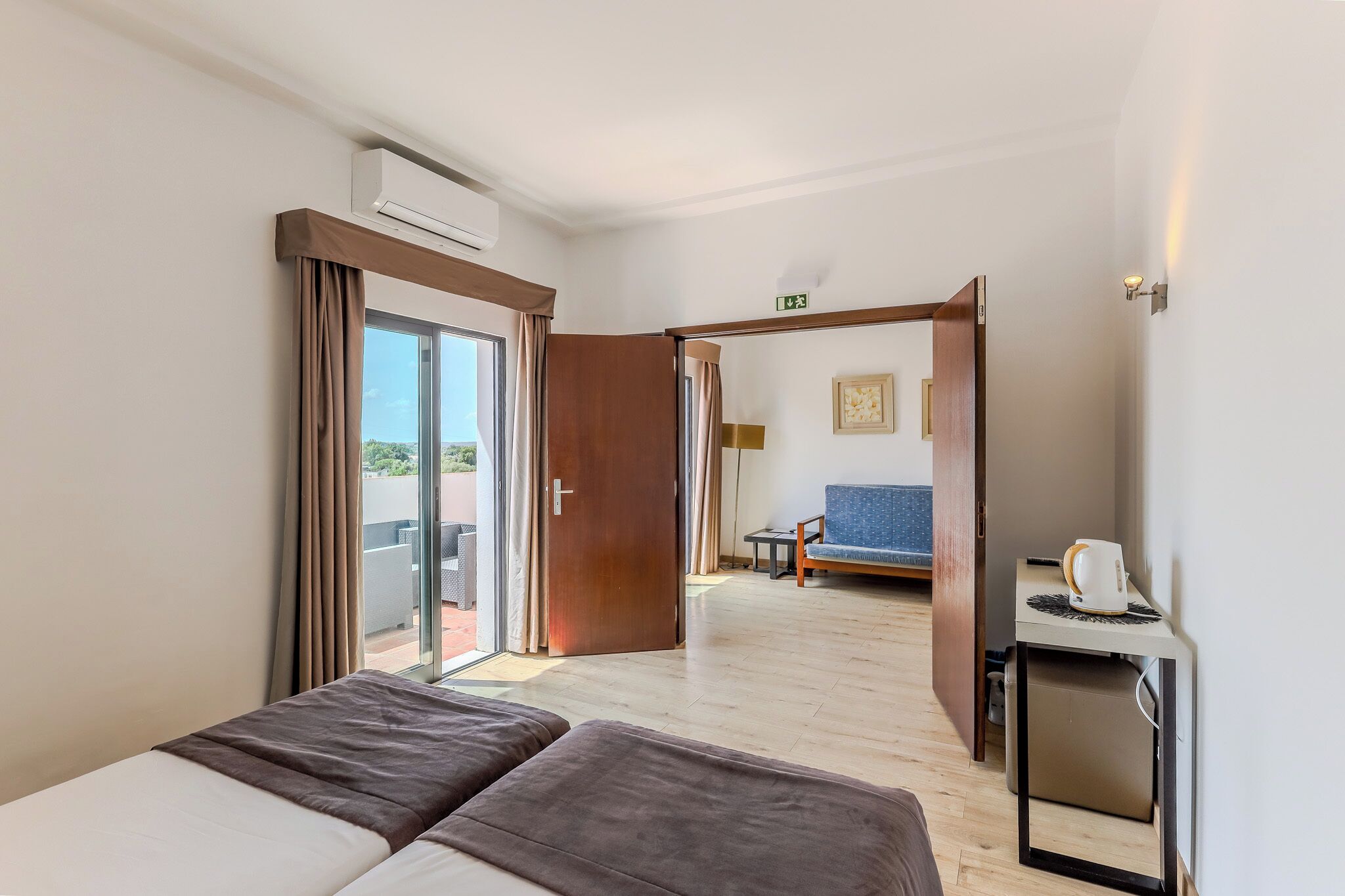 Une chambre d’hôtel avec un lit, un bureau, une chaise et une vue sur l’extérieur.