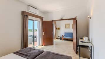 Une chambre d’hôtel avec un lit, un bureau, une chaise et une vue sur l’extérieur.