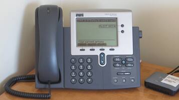 A Cisco IP phone with a display screen, keypad, and a handset.