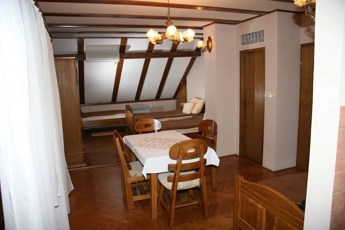 Ein Essbereich mit Holztisch und Stühlen, einer Kandelaber und einem Fenster mit Blick nach draußen.