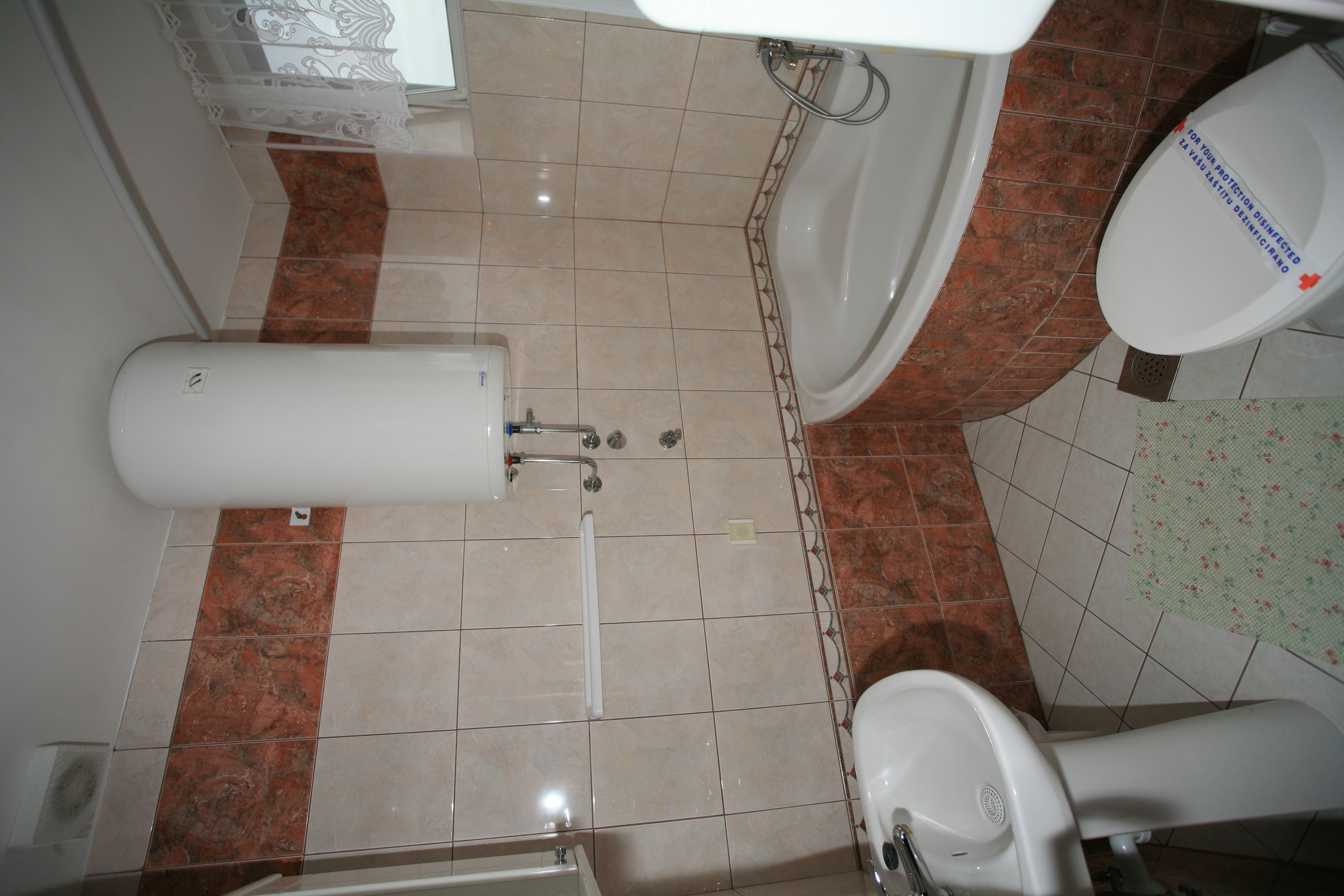 Ein Badezimmer mit Toilette, Bidet und einem Händetrockner.