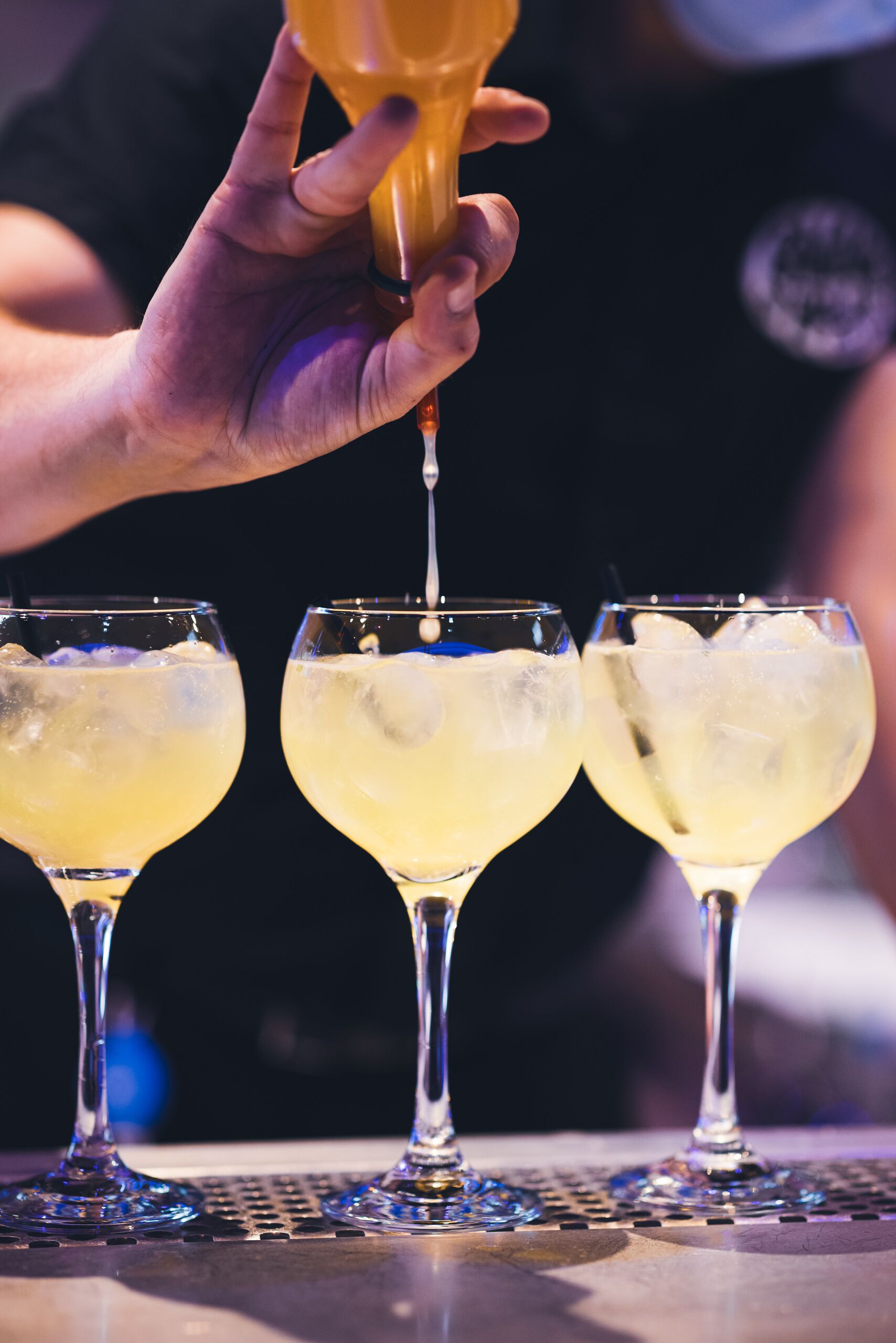 A bartender pouring a drink into a glass.