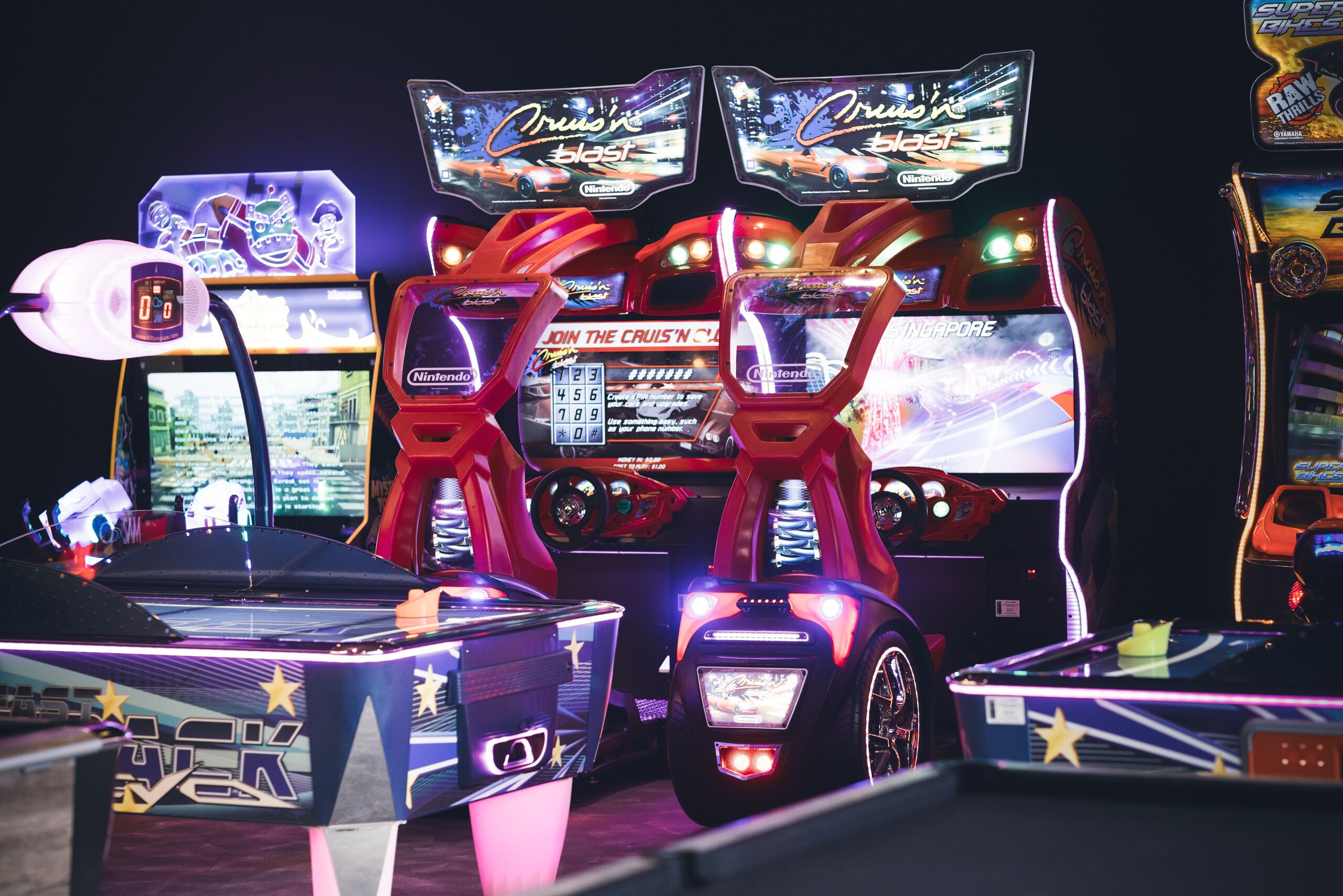 Máquinas de arcade con luces de neón y pantallas de juego.