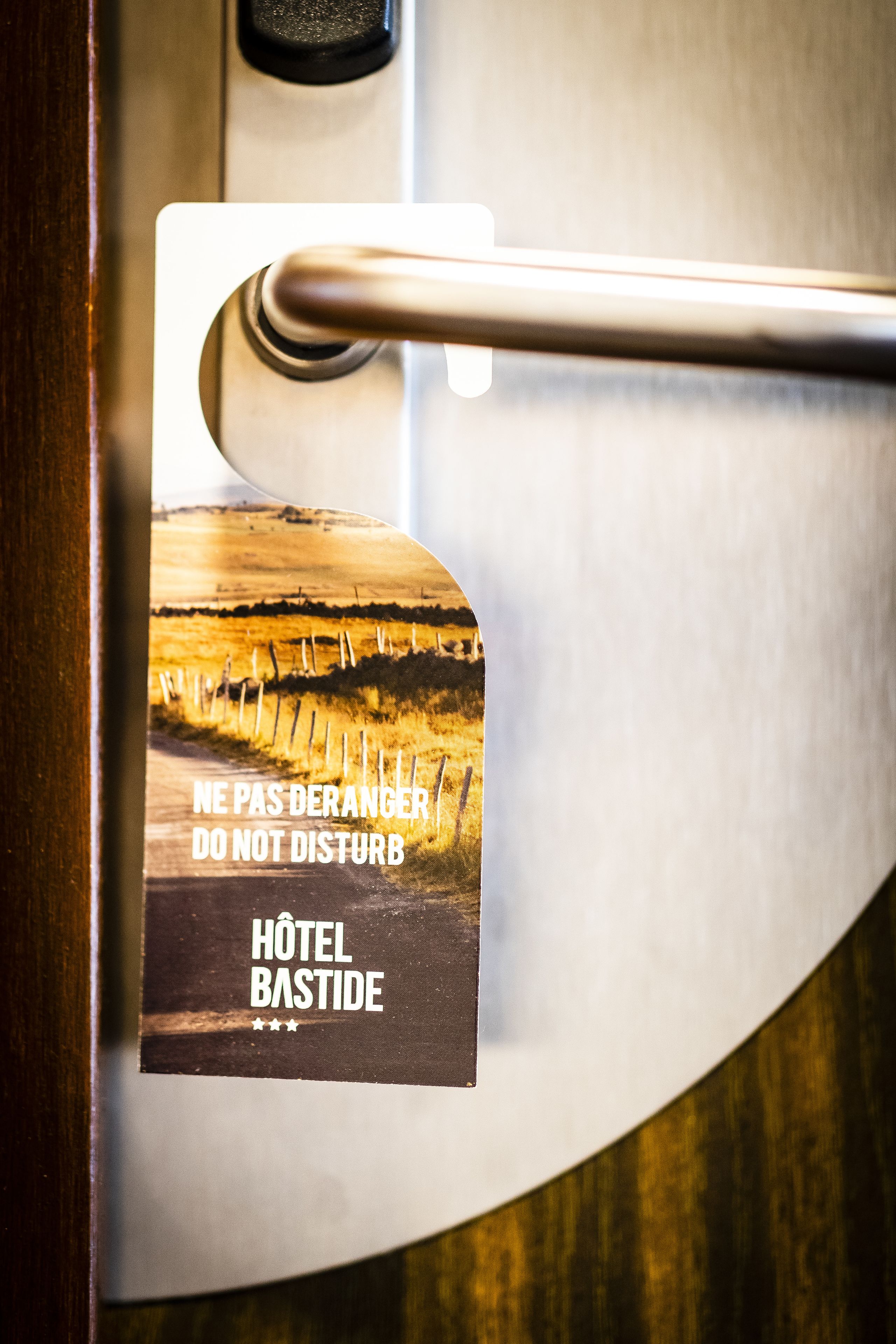 A hotel door handle with a sign that reads "NE PAS DERANGER DO NOT DISTURB HOTEL BASTIDE".