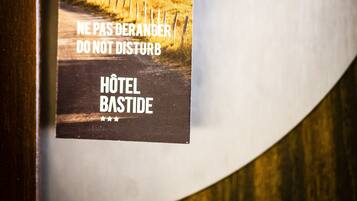 Une poignée de porte d’hôtel avec une pancarte indiquant : « NE PAS DÉRANGER – HOTEL BASTIDE ».