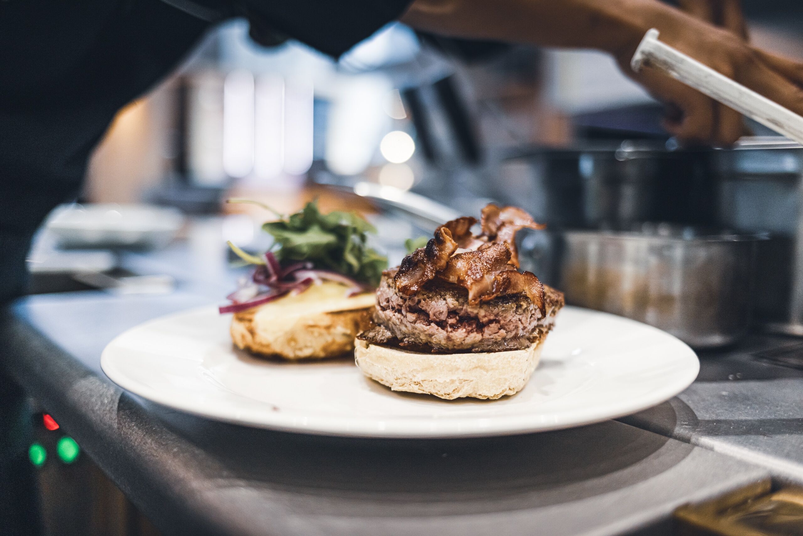 A plate with a burger and a salad on a table in a restaurant.