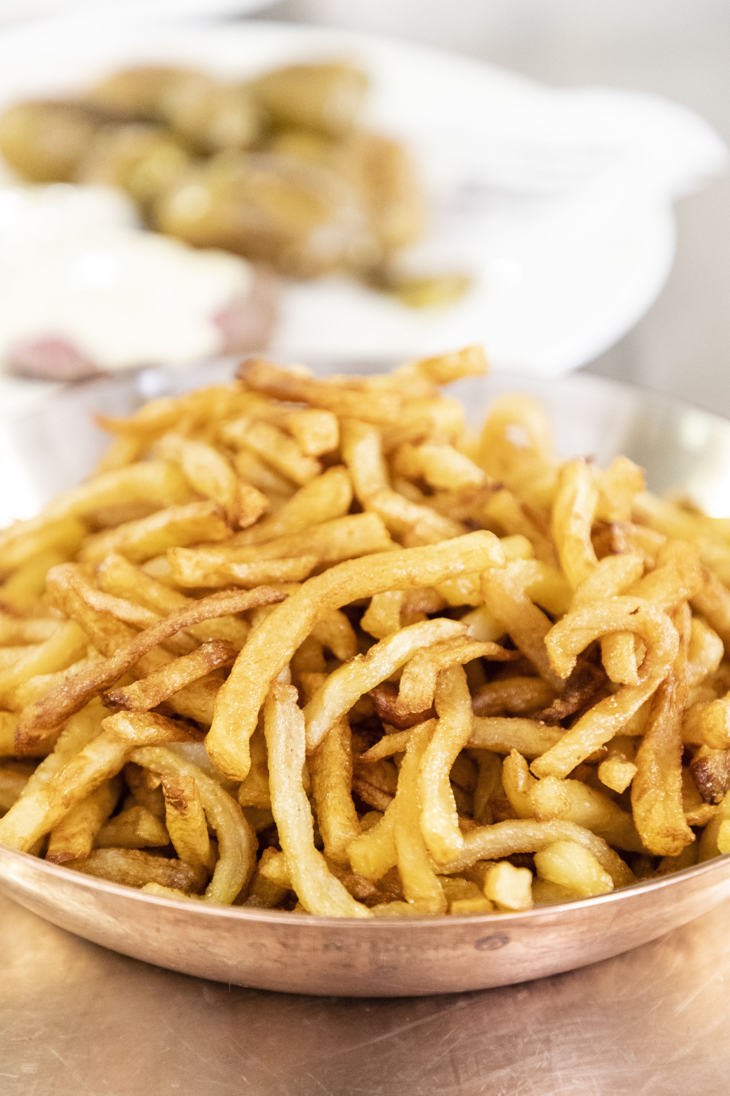 A close-up of a bowl filled with golden-brown fried onion rings.