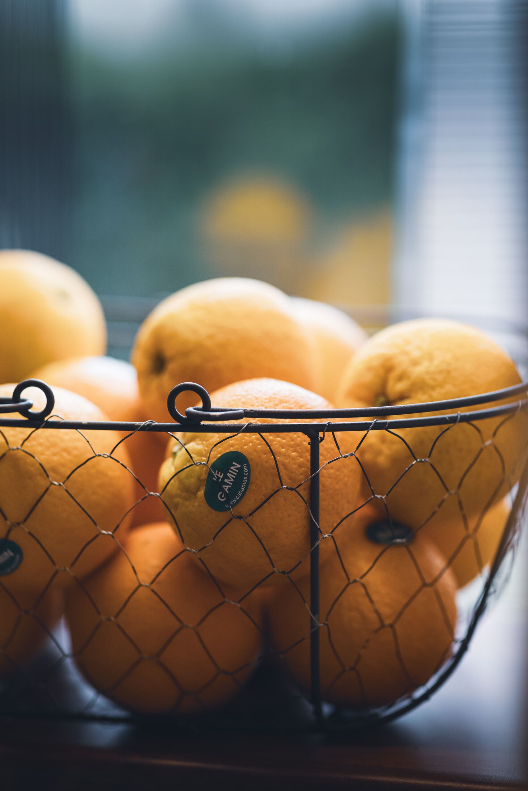 Una cesta de alambre con naranjas.