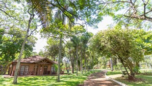 Un edificio rústico con tejado de baldosas, rodeado de abundante vegetación y árboles.