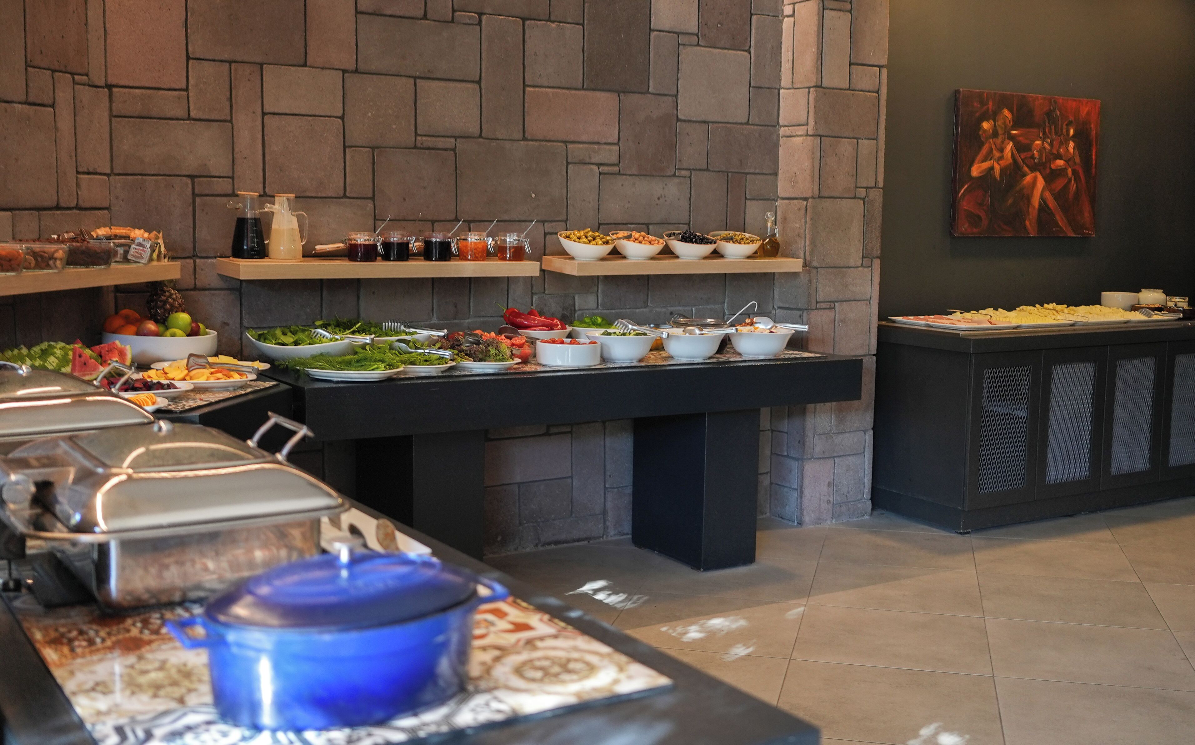 Una mesa de buffet con diferentes alimentos y un cuadro en la pared.