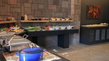 Una mesa de buffet con diferentes alimentos y un cuadro en la pared.