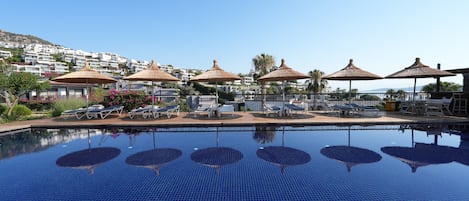 Piscine extérieure, parasols de plage, chaises longues