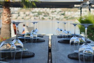 A wooden table set with wine glasses and plates, likely for a dining event.