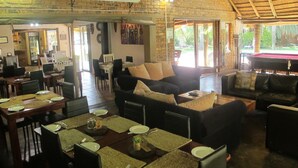 A spacious indoor area with a dining setup, seating arrangements, and a pool table. - Aero Guest Lodge (Kempton Park)