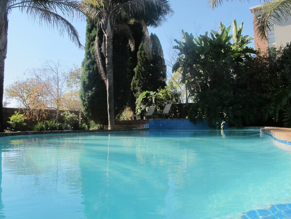 Alberca al aire libre y camastros 