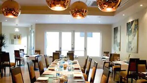 Une salle de conférence avec une longue table, des chaises et un éclairage au plafond.
